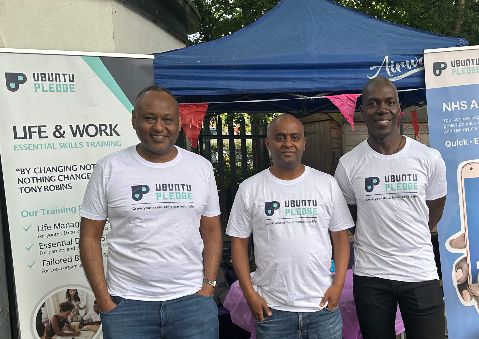 Three Ubuntu Pledge team members at a community outreach stand